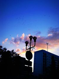 Low angle view of silhouette sign against sky