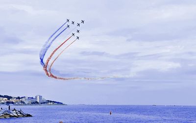 Airplane flying over sea against sky