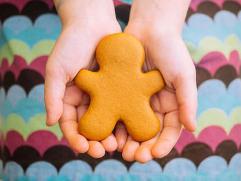 Cropped hand holding gingerbread cookie