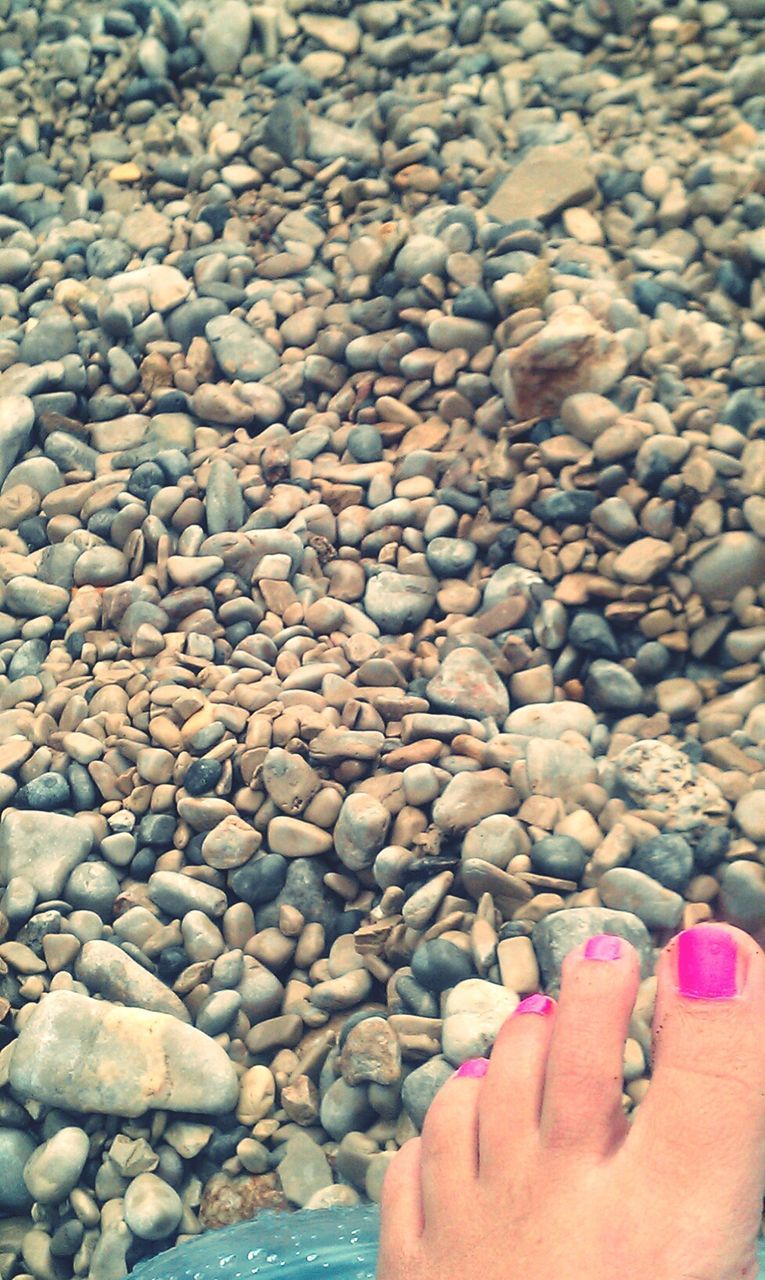 person, lifestyles, part of, personal perspective, leisure activity, unrecognizable person, beach, water, low section, cropped, human finger, stone - object, high angle view, human foot, barefoot