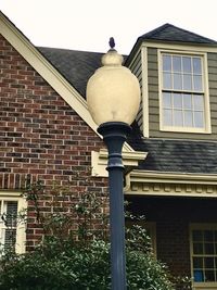 Low angle view of street light against building