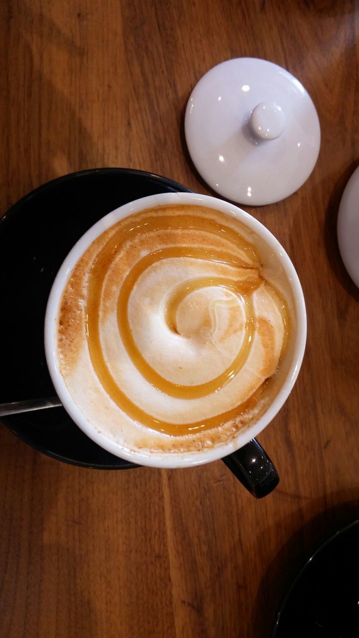 food and drink, indoors, table, freshness, coffee cup, drink, refreshment, still life, coffee - drink, cappuccino, saucer, high angle view, frothy drink, froth art, directly above, wood - material, coffee, close-up, spoon, cup