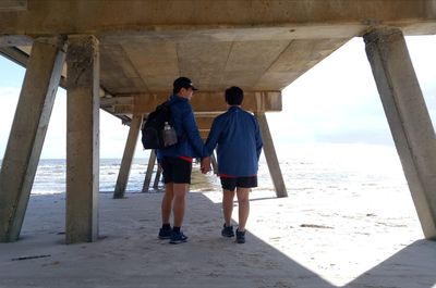 Rear view of people walking on beach