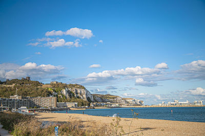 Scenic view of sea by buildings against sky