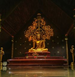 Statue at illuminated temple in building