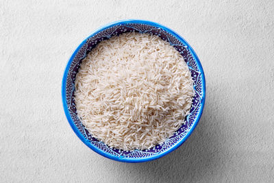 Directly above view of raw rice in bowl on table