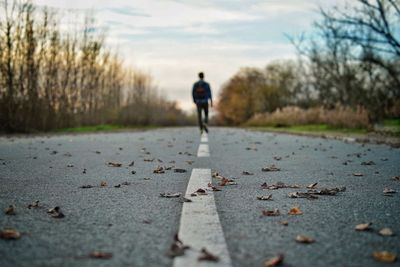 Rear view of man walking on road