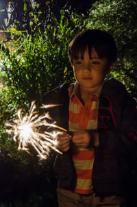 Boy standing in park at night