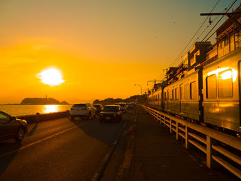 Cars on street against orange sky