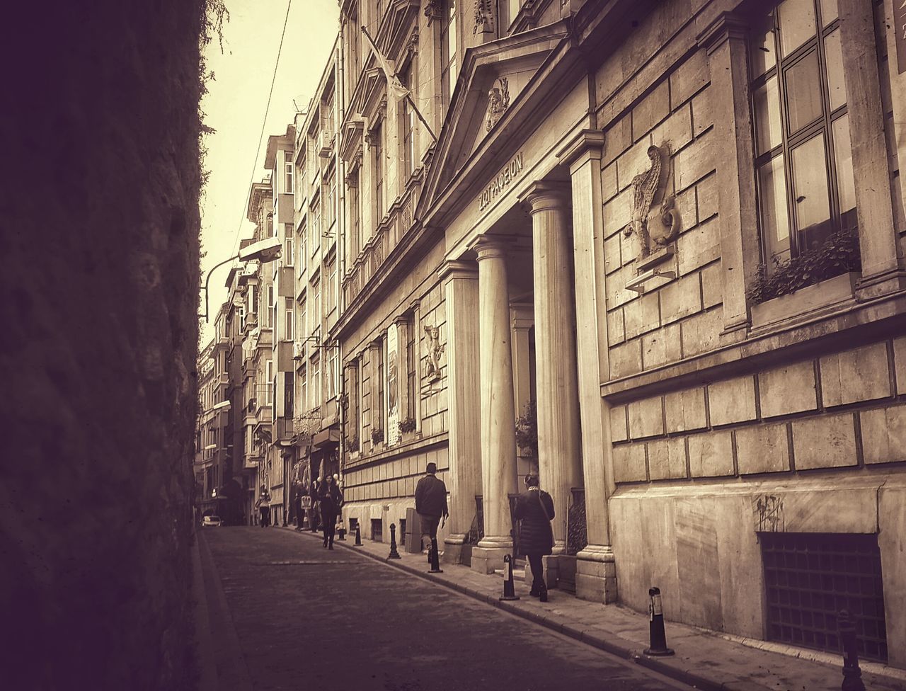 architecture, built structure, building exterior, history, travel destinations, person, building, men, famous place, street, facade, day, travel, walking, tourism, clear sky, the way forward, city, outdoors