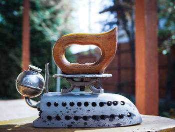 Close-up of tea light on table by tree