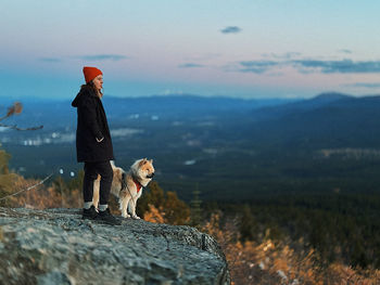 Side view of woman standing on rock