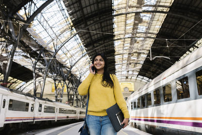 Portrait of smiling woman standing on railway station