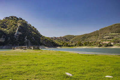 Scenic view of sea and mountains against clear sky