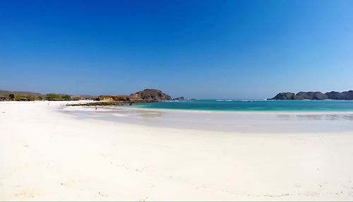 Scenic view of beach against clear blue sky