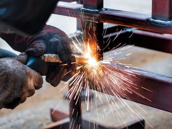 Cropped image of manual worker welding railing