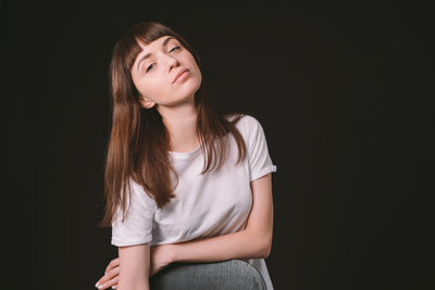 Portrait of a beautiful young woman over black background