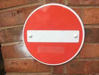 Close-up of a stop sign on a red brick wall. 