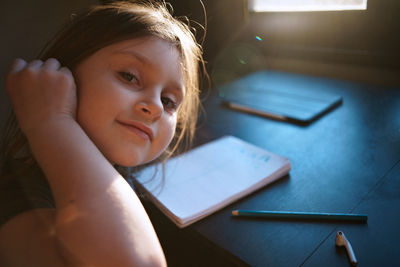 Portrait of woman holding book at home