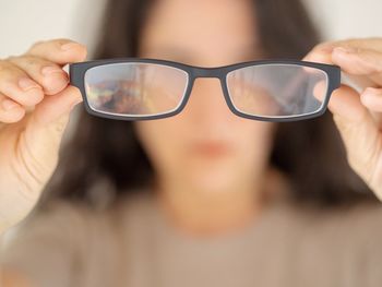 Midsection of woman holding sunglasses