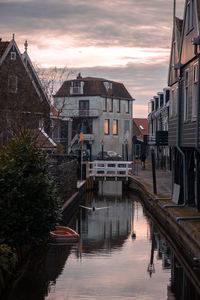 Canal amidst buildings against sky during sunset