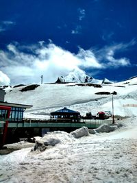 Snow covered mountain against cloudy sky