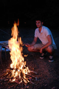 Young man sitting in bonfire