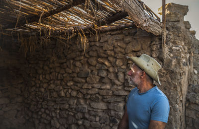 Adult man in cowboy hat and jean in a rural area