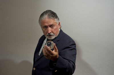 Portrait of man standing against white background