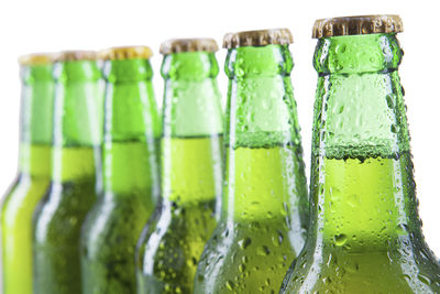 Close-up of green beer bottle against white background