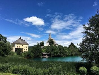 Scenic view of lake by buildings against sky