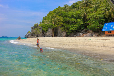 People swimming in sea on island