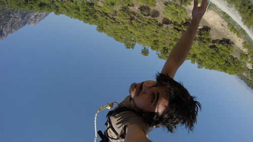 Low angle view of man against clear blue sky