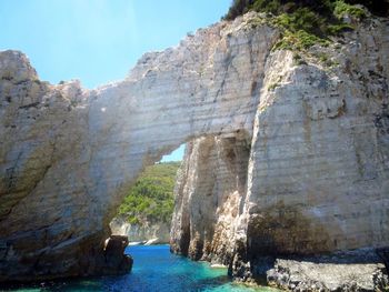 Rock formations by sea against sky