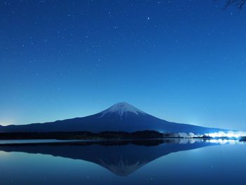 Scenic view of lake against clear blue sky at night