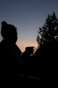 Silhouette man standing against sky during sunset