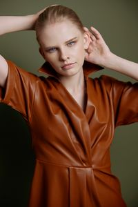 Portrait of young woman against yellow wall