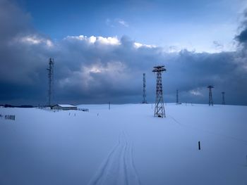 Transmission towers in the mountains during winter on a cloudy day