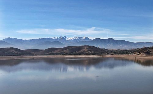 Scenic view of lake and mountains against blue sky