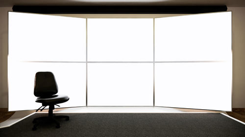 Empty chair on table against wall