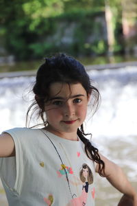 Portrait of girl standing against river