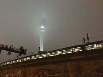 Low angle view of illuminated bridge against sky at night