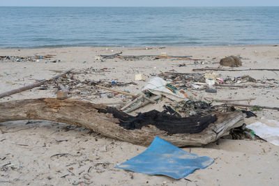 Garbage on sand at beach against sky