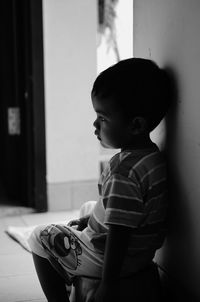 Thoughtful boy sitting in home