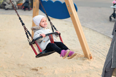 Full length of girl enjoying on swing