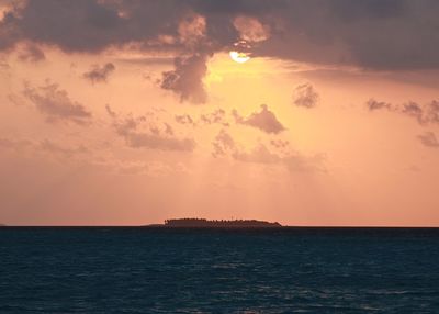 Scenic view of sea against cloudy sky during sunset