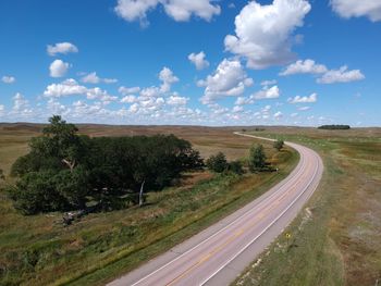 Empty road by land against sky