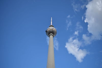 Low angle view of communications tower against blue sky
