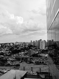 View of cityscape against cloudy sky