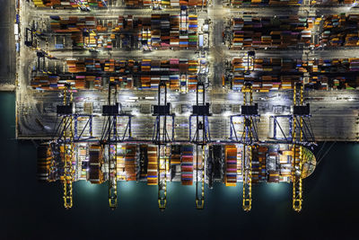 Aerial top view container yard in the harbor area, container ship working at night.